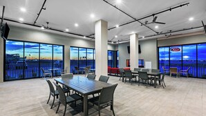 A spacious conference room with a large table and chairs, large windows with a city view, and ceiling fans. - Holiday Inn Lubbock South by IHG (Lubbock)