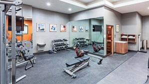 A gym with exercise equipment, a mirror, and a shoe rack. - Holiday Inn Lubbock South by IHG (Lubbock)