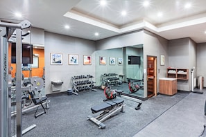 A gym with exercise equipment, a mirror, and a shoe rack. - Holiday Inn Lubbock South by IHG (Lubbock)