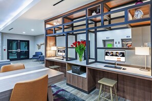 A modern hotel lobby with a reception desk, seating area, and a large window. - Holiday Inn Lubbock South by IHG (Lubbock)