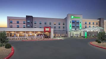A Holiday Inn hotel with a Burger Theory restaurant, a covered entrance, and a clear sky.