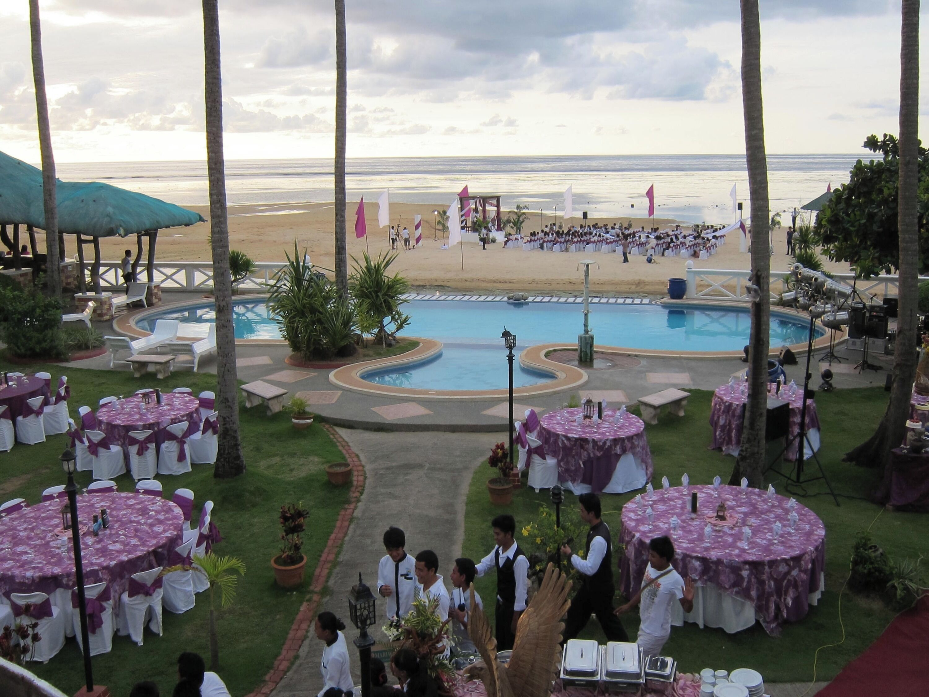 Un espace aménagé au bord de la piscine, comprenant plusieurs tables rondes, des chaises et une piscine.