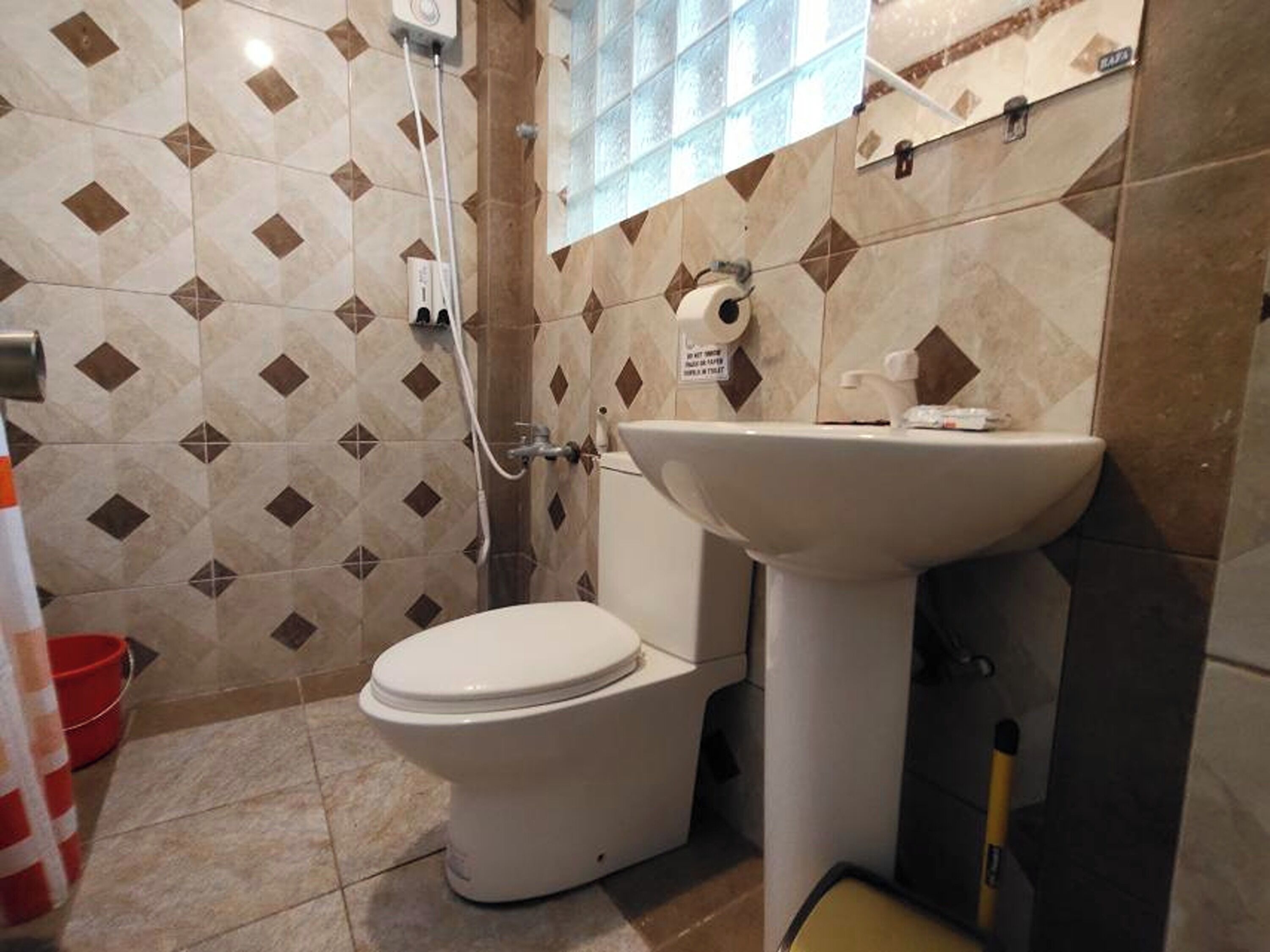 Un baño con inodoro, lavamanos y ducha.