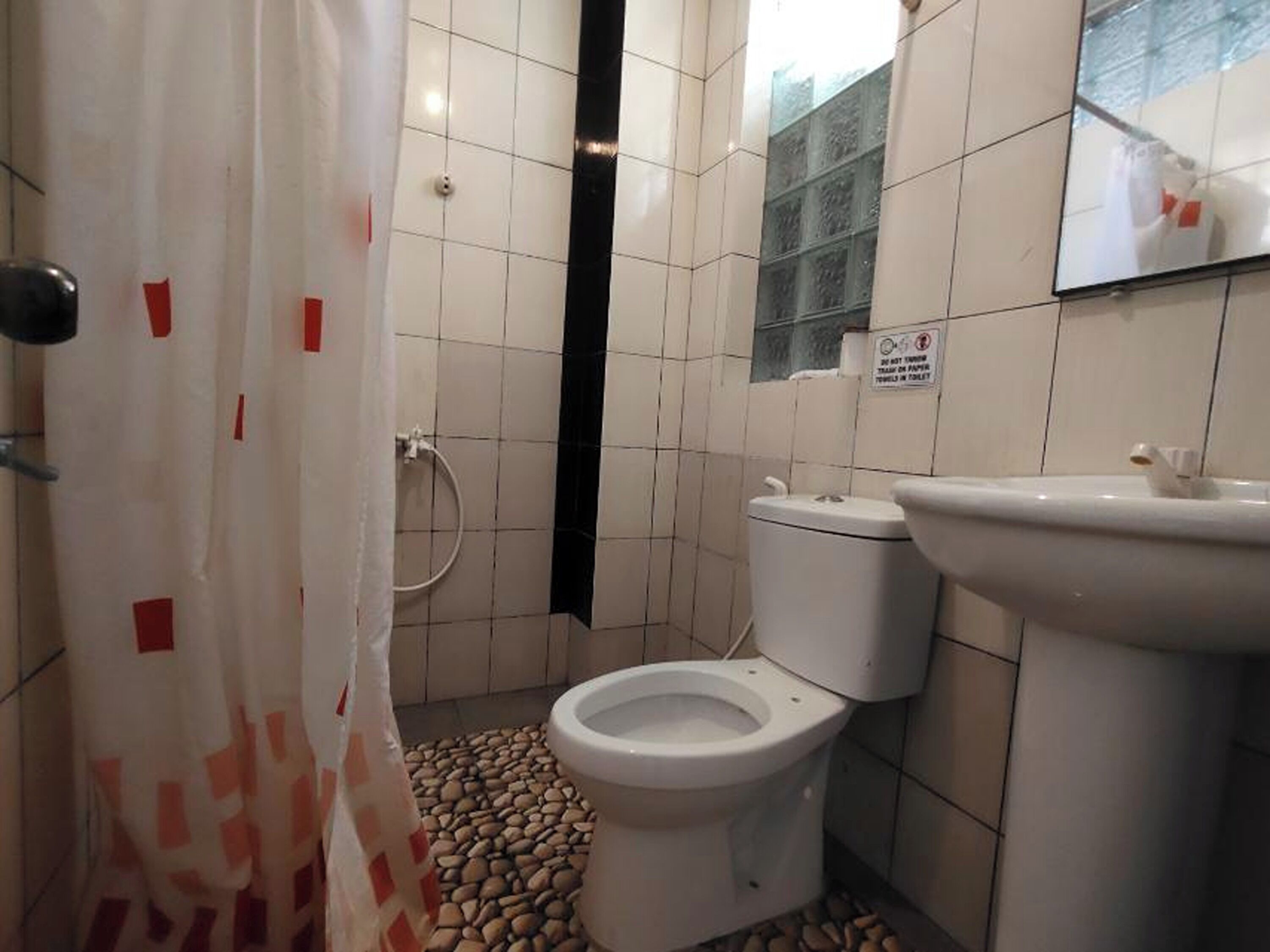 Un baño con inodoro, lavamanos y zona de ducha.