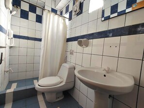A bathroom with a toilet, a sink, and a shower curtain.