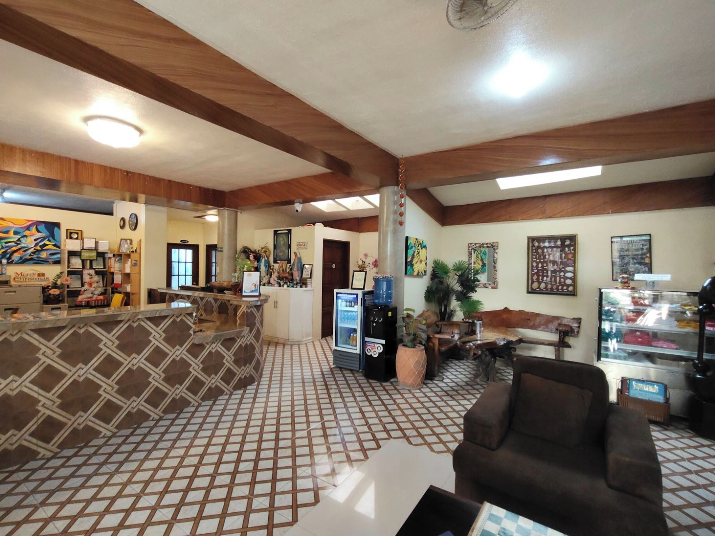 A lobby with a reception desk, seating area, and a water cooler.