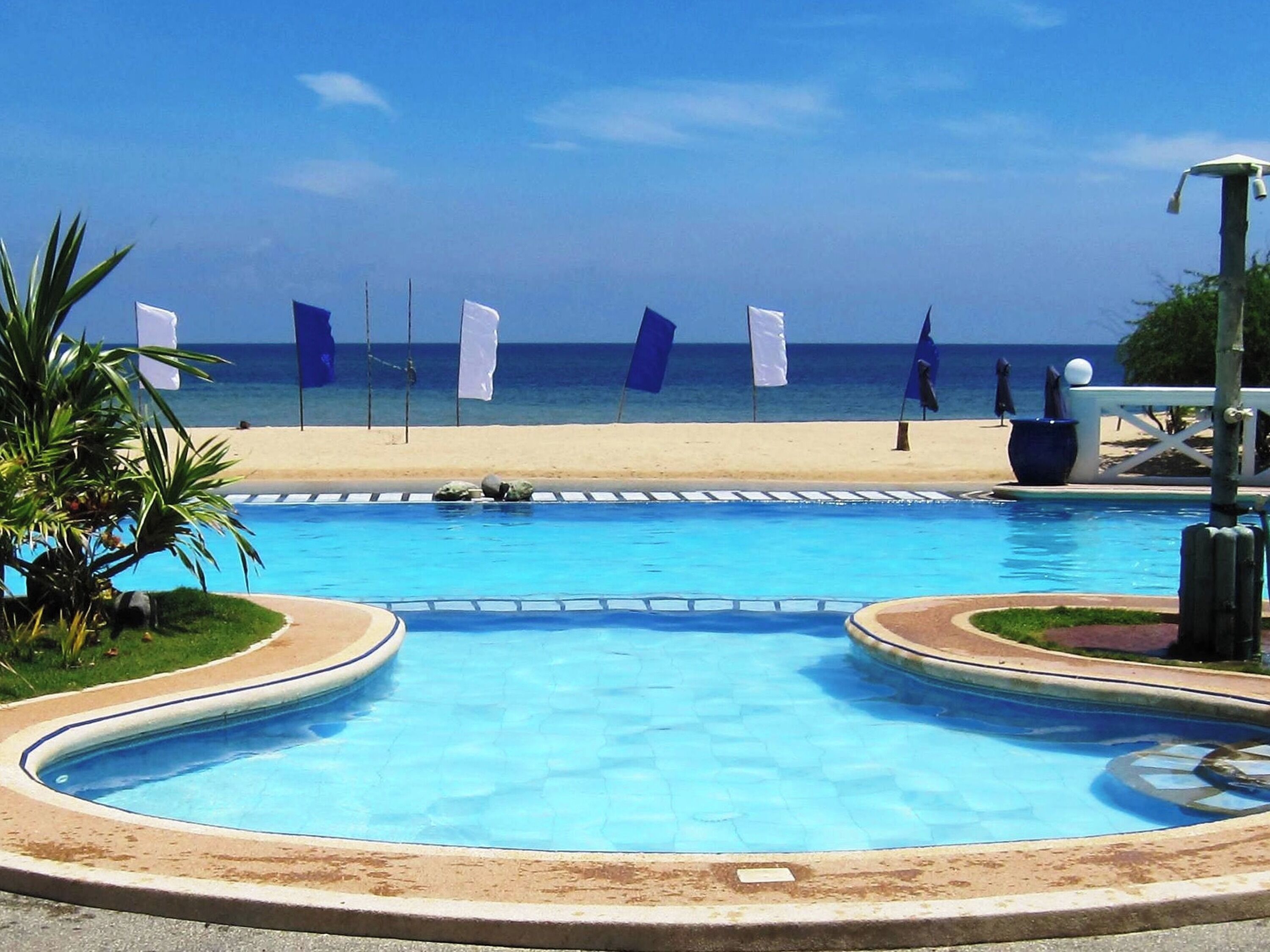 A swimming pool with a view of the beach and ocean.
