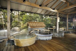 Una tradizionale onsen giapponese con panche in legno e vasche termali in pietra.