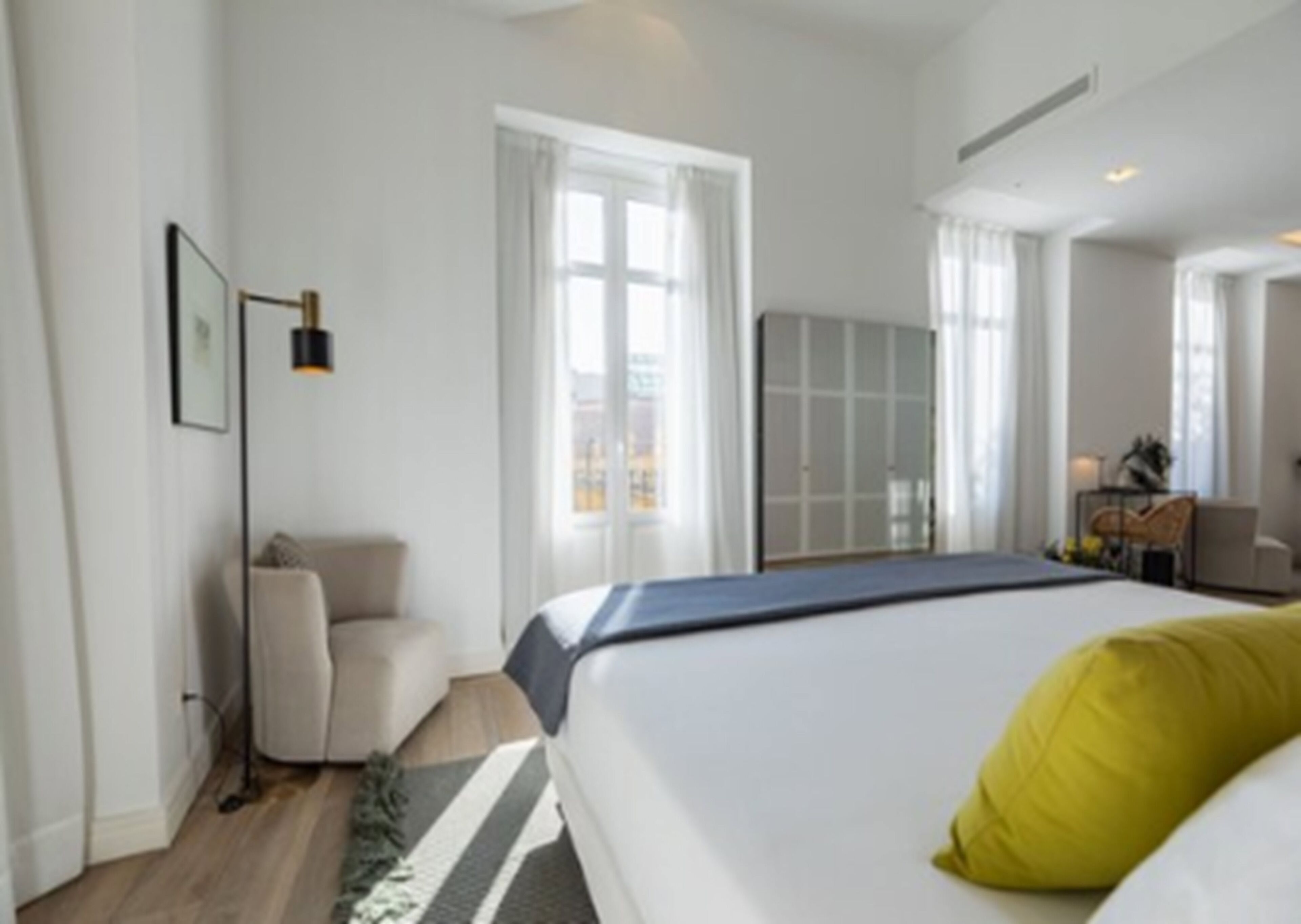 Una habitación de hotel moderna con una cama grande, un escritorio y una silla.