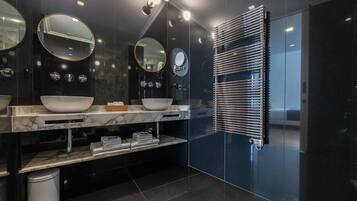 A modern bathroom with two sinks, marble countertops, and a towel rack.