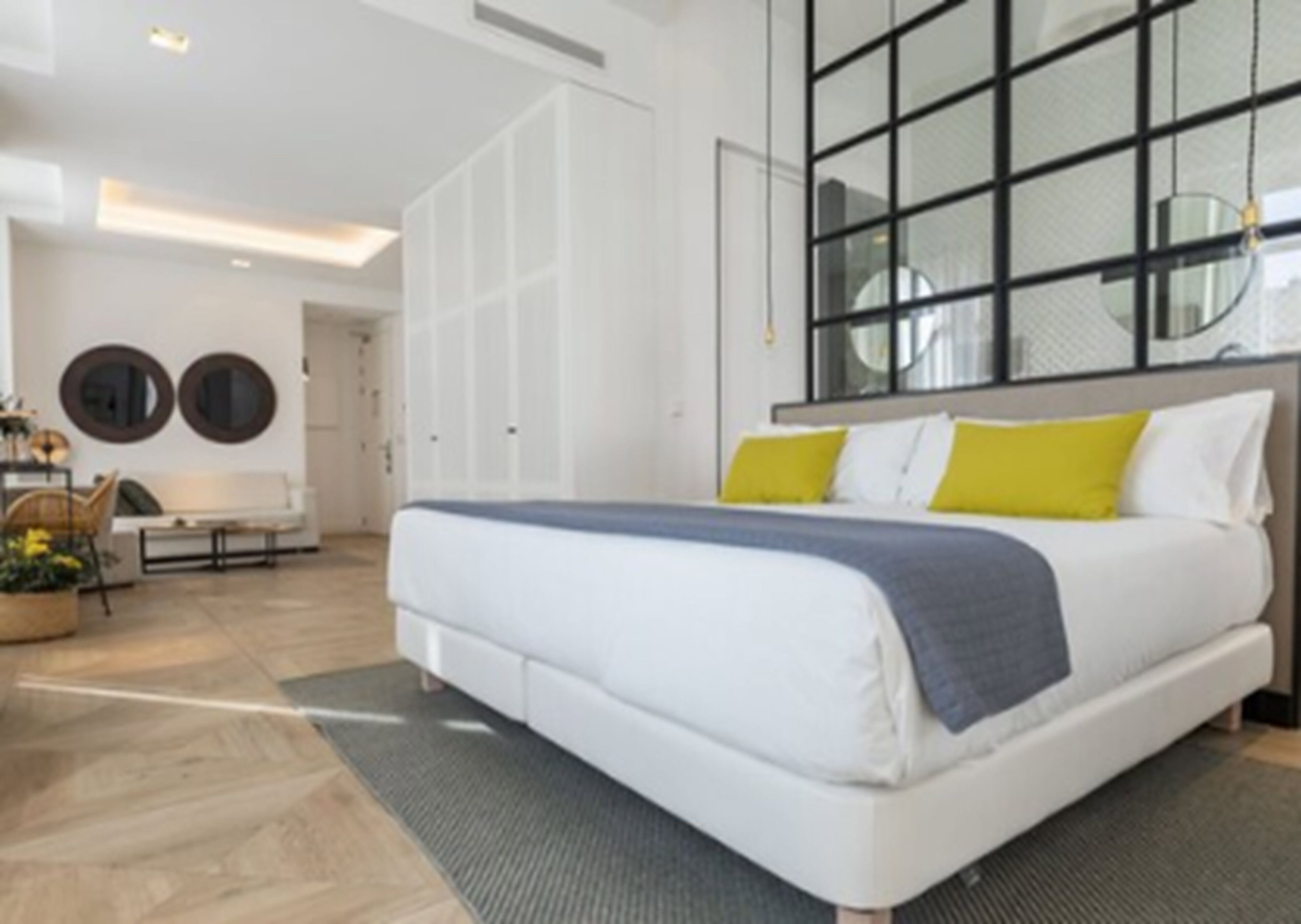 Una habitación de hotel moderna con una cama grande, un escritorio y una zona de estar con sillas.