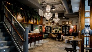 A modern interior with a staircase, bar area, seating, and chandeliers. - MYR Marqués House Hotel (Valencia)