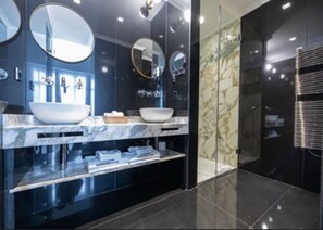 A modern bathroom with a large vanity, two sinks, and multiple mirrors. - MYR Marqués House Hotel (Valencia)