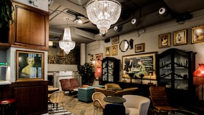 A cozy lounge area with a mix of seating options, including sofas and chairs, a bar area with stools, and a decorative chandelier. - MYR Marqués House Hotel (Valencia)
