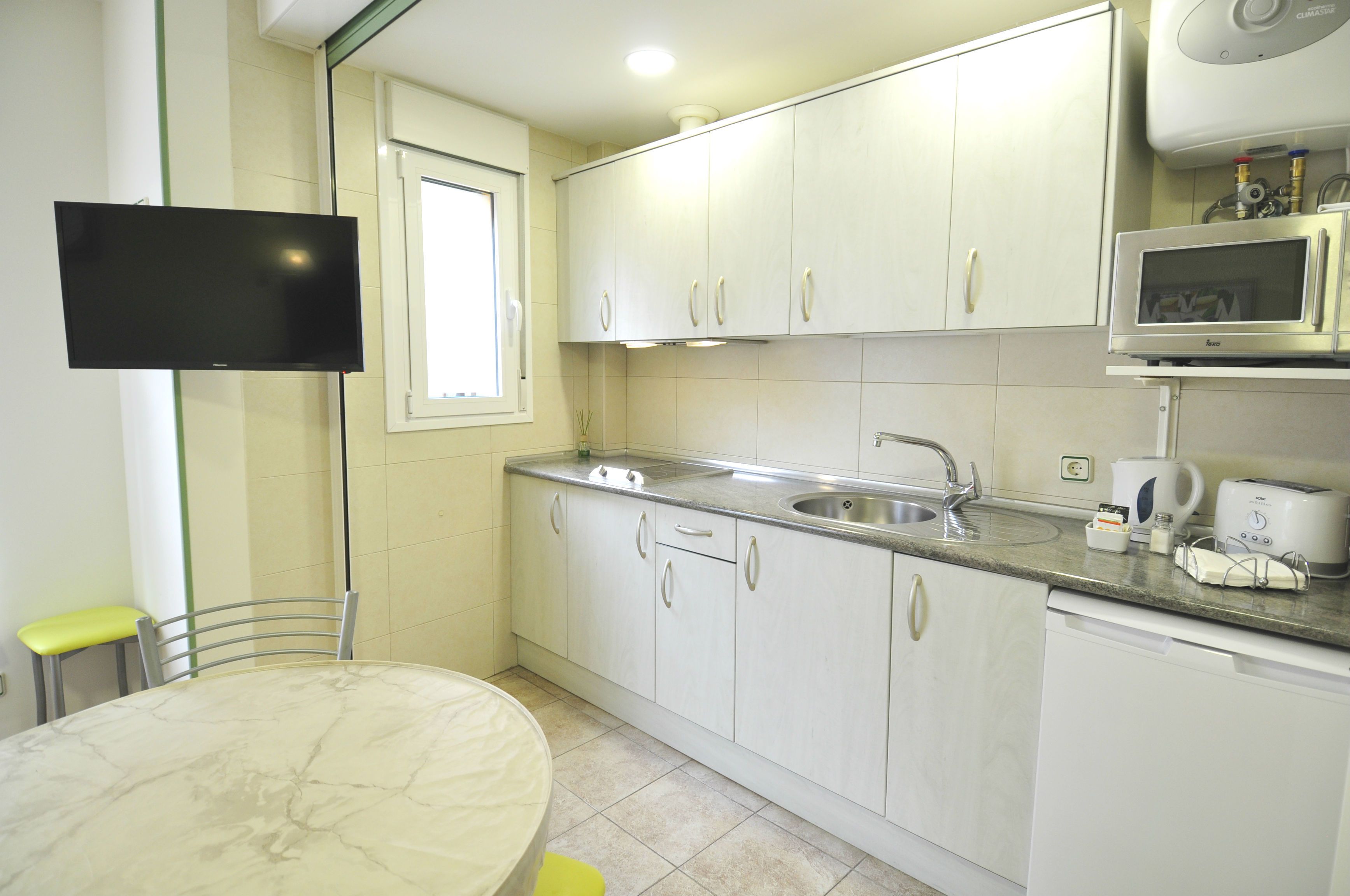 A kitchen with white cabinets, a built-in microwave, and a sink.