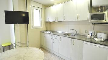 A kitchen with white cabinets, a built-in microwave, and a sink.
