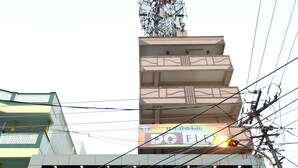 A building with a 'BAR' and 'Hotel Boopathi' sign, featuring a glass facade and a staircase leading to the entrance. - Hotel Boopathi (Madurai)