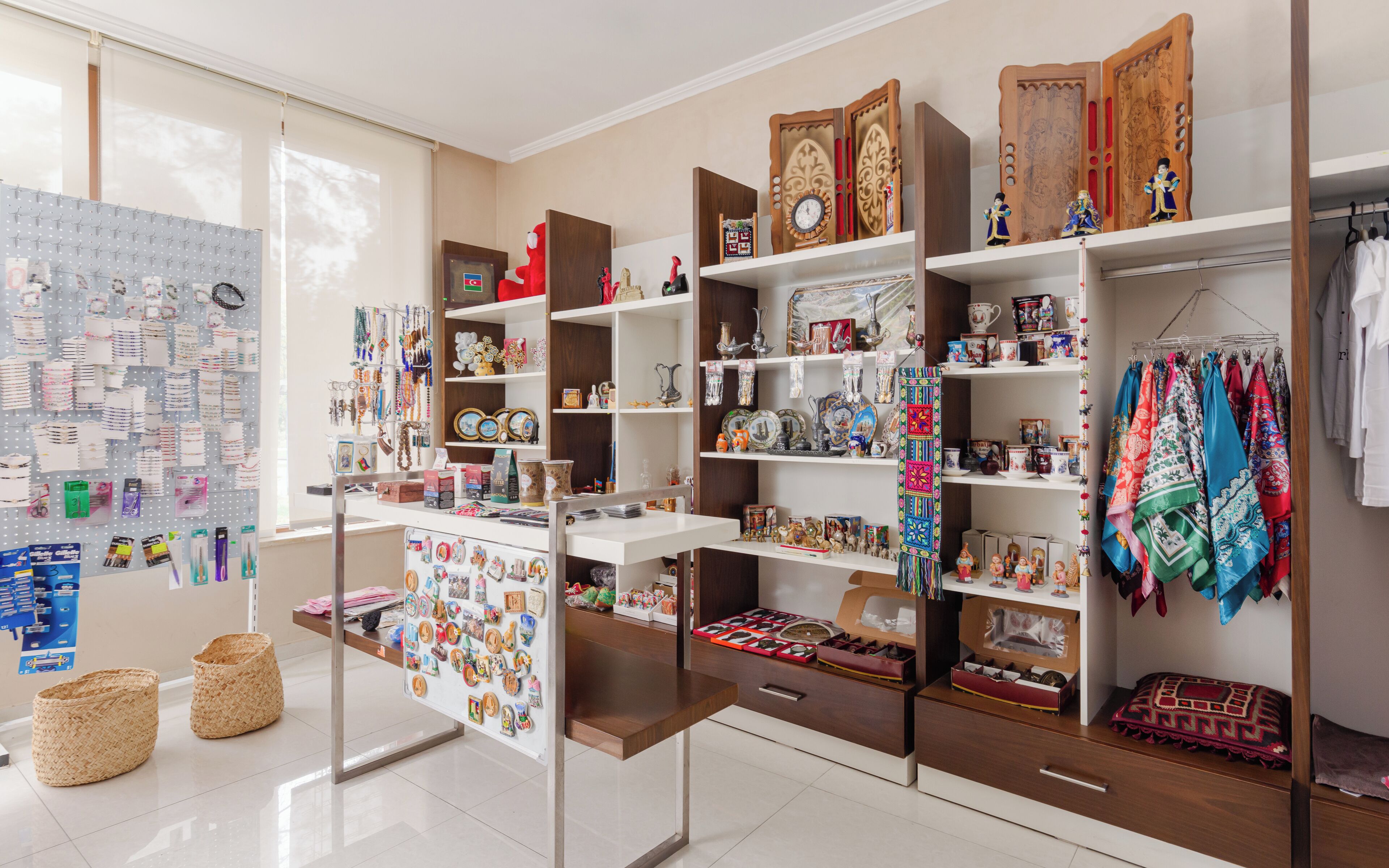 A well-organized room with shelves displaying various items, a pegboard with hanging items, and a bed with a patterned blanket.