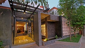 A modern building with a covered entrance, a small garden area, and a pathway leading to the entrance. - Country Inn (Siem Reap)