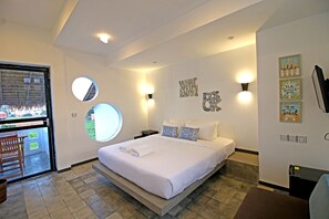 Ein modernes Schlafzimmer mit einem großen Bett, einem runden Fenster und Blick ins Freie.