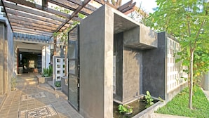 A modern outdoor area with a concrete structure, a small water feature, and a tiled walkway. - Country Inn (Siem Reap)