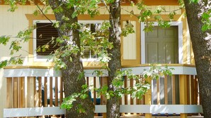 A two-story building with a balcony and a window with shutters. - Giant Oaks Lodge (Running Springs)