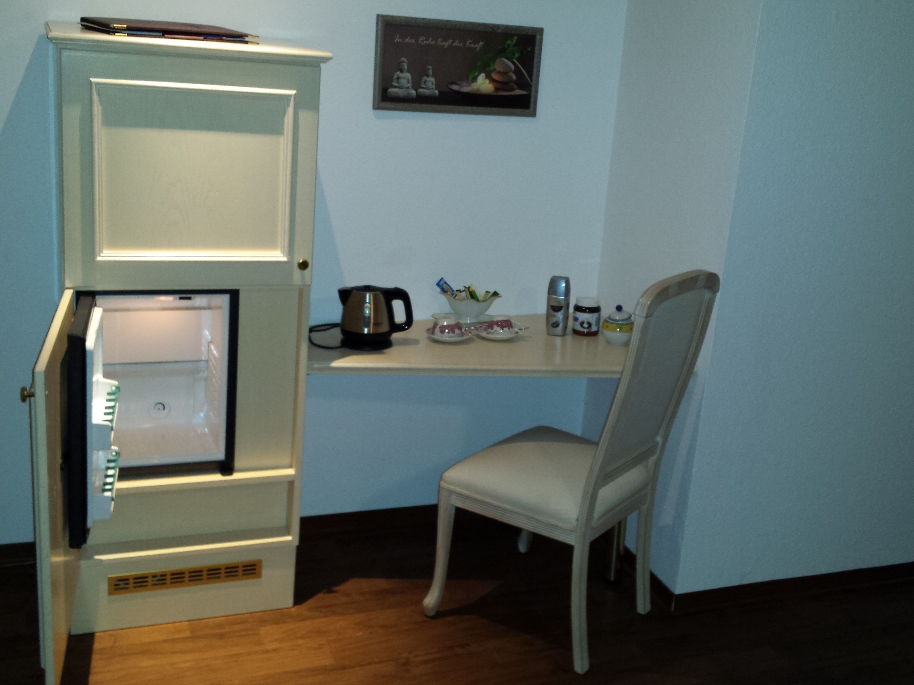 Una cocina compacta con refrigerador integrado, una pequeña encimera y una silla.