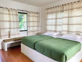 Um quarto com cama, cortinas e uma janela.