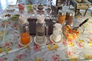 Une table de petit-déjeuner avec divers aliments et condiments.