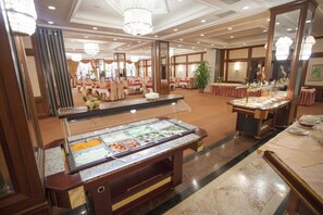 Enjoy a formal dining experience in our elegant dining area, featuring a variety of buffet stations and classic design elements.