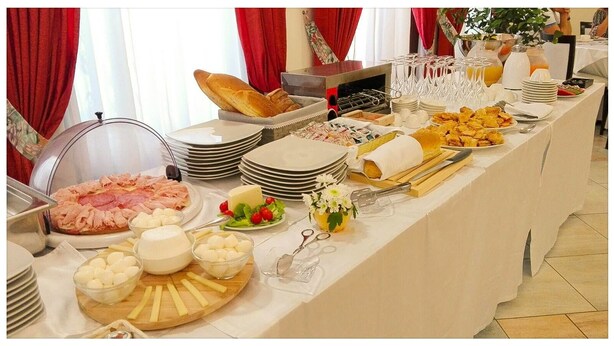 Una mesa de buffet con distintos alimentos y utensilios.