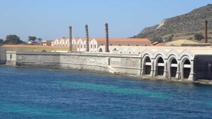 Un bâtiment situé sur la côte, doté d’une série d’arches et d’un portique, et offrant une vue sur une étendue d’eau.