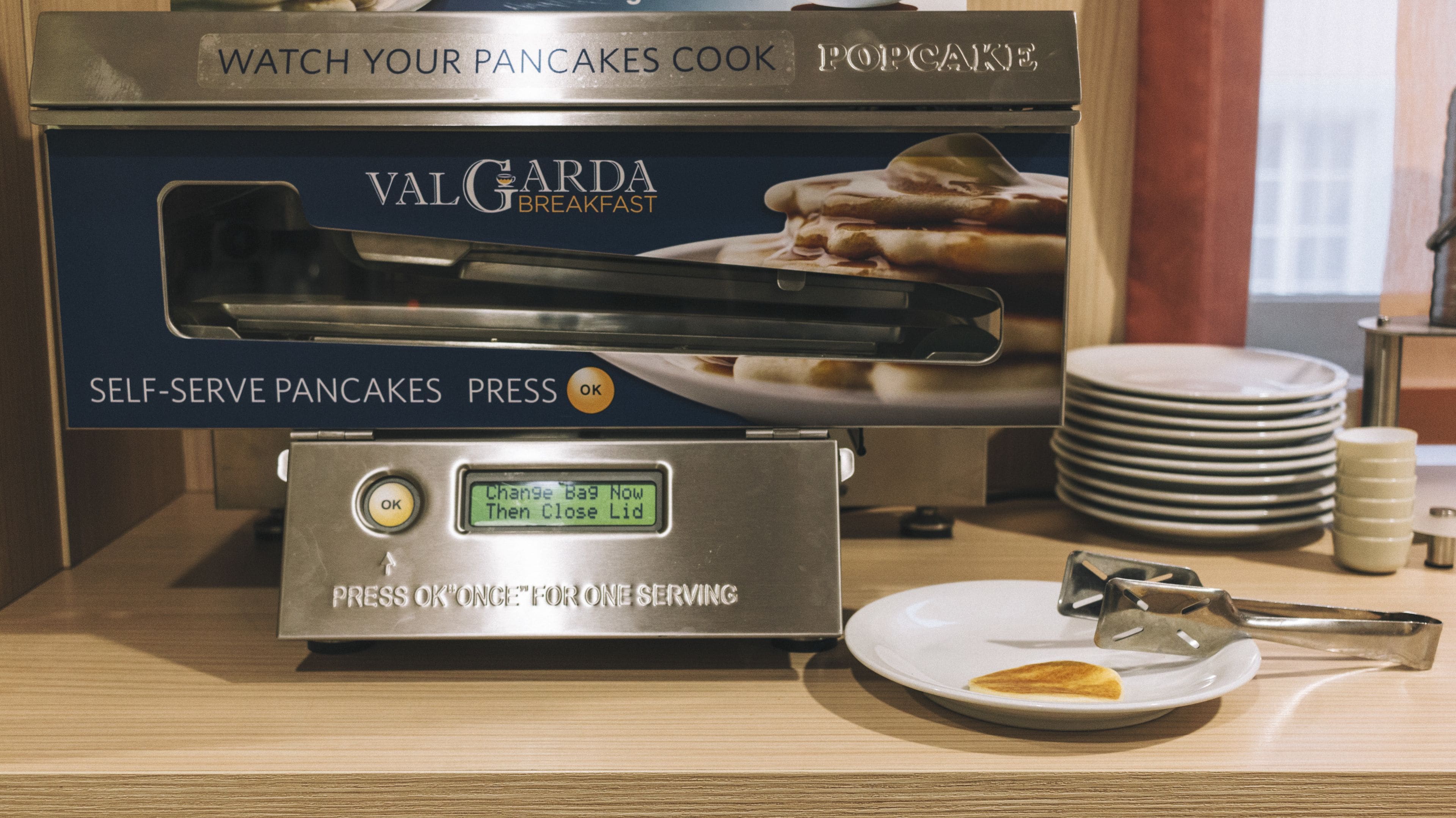 A self-serve pancake press with instructions and a digital display.