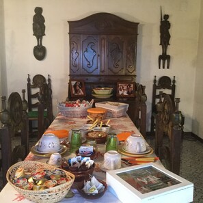 Une table à manger dressée avec différents plats, un buffet et des éléments de décoration murale.