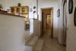 Un escalier menant à une salle à manger équipée d’un buffet en bois et de chaises.