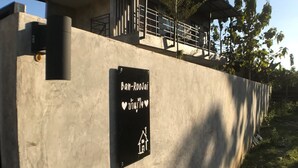 A concrete building with a sign that reads "Ban-Roojai" and a heart symbol. - Ban Roojai (Nan)
