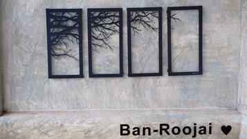 Four black tree silhouettes on a marble wall, with the text "Ban-Roojai" and a heart symbol below.