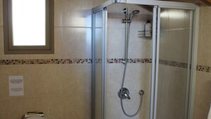A bathroom with a glass-enclosed shower, a toilet, and a bidet.