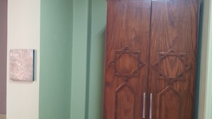 A room with a wooden wardrobe featuring star-shaped handles and a decorative panel. - Downtown Inn (Cairo)