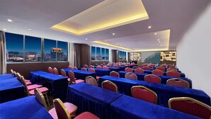 A conference room with rows of tables and chairs, large windows with a city view, and a modern ceiling design. - Yizhi flat (Guangzhou Zhujiang New Town Huashi Subway Station Branch) (Guangzhou)