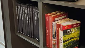 Ein Bücherregal mit Reisebüchern, darunter ein gut sichtbarer 'Frommer's Italy 2024' Reiseführer.