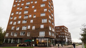 A multi-story brick building with a Starbucks on the ground floor. - StudentStay (Leeuwarden)
