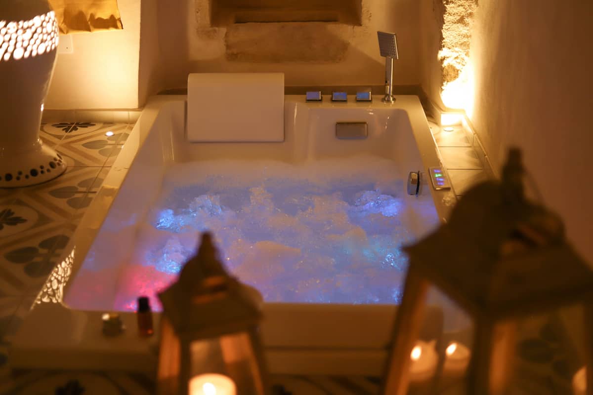 A bathtub with a built-in heater, a towel, and a control panel.
