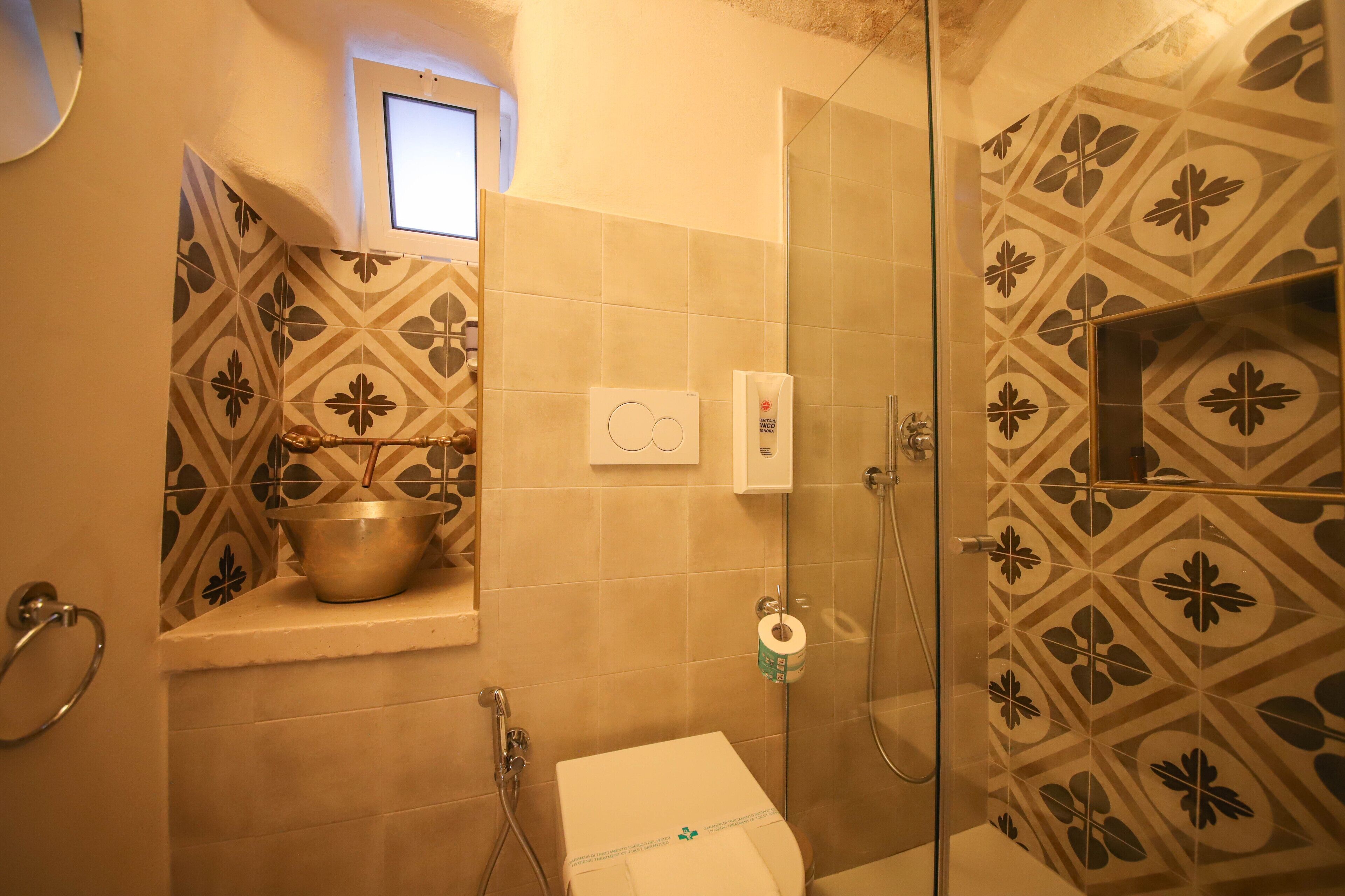 A bathroom with a shower, a toilet, and a sink.