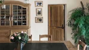 Un comedor con una mesa de madera rústica, sillas e iluminación colgante de un candelabro.