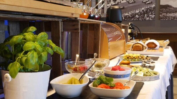 Ett buffébord med olika sorters mat, inklusive skålar med sallad, frukt och tillbehör.