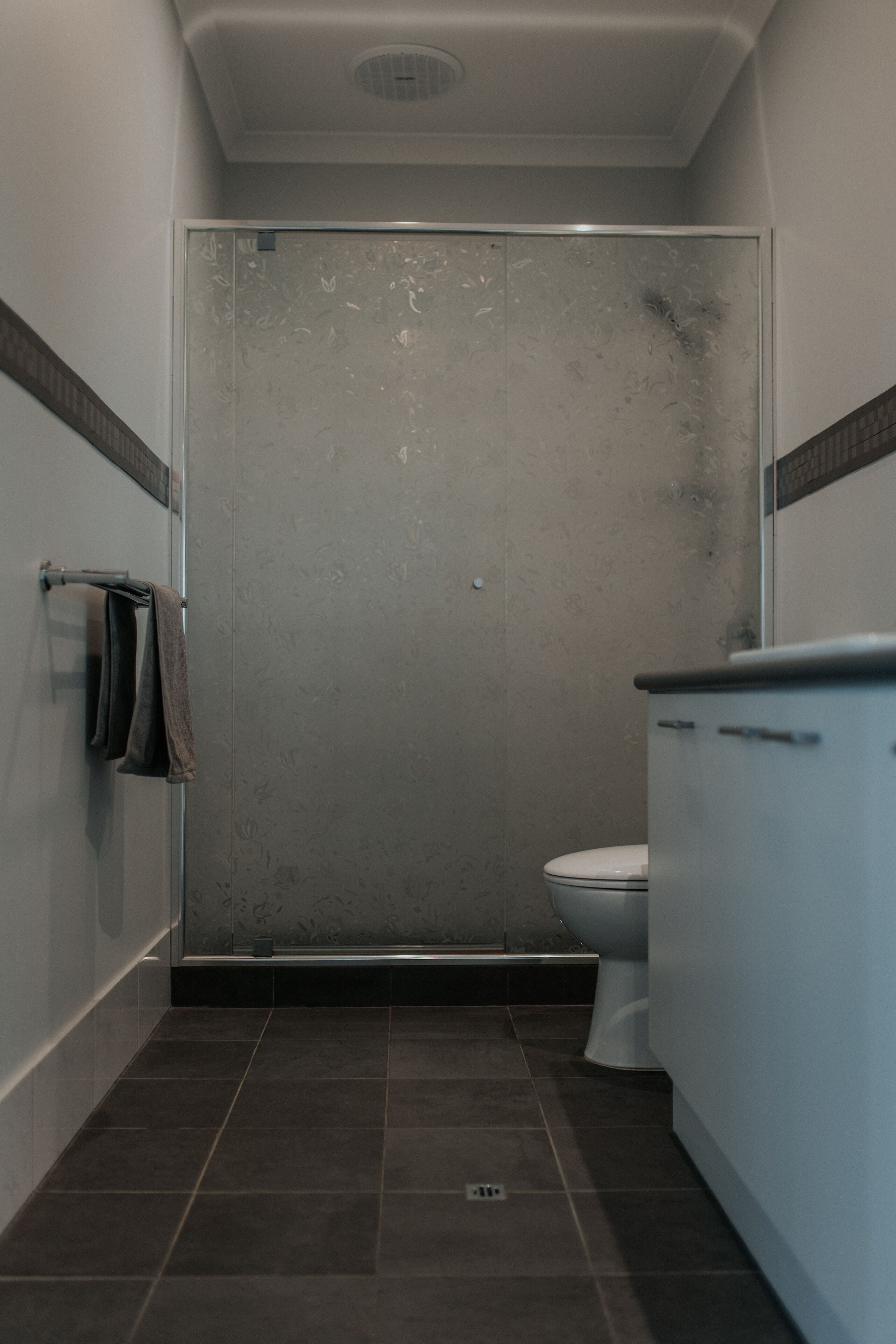 A bathroom with a shower, toilet, and sink.