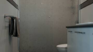 A bathroom with a shower, toilet, and sink.