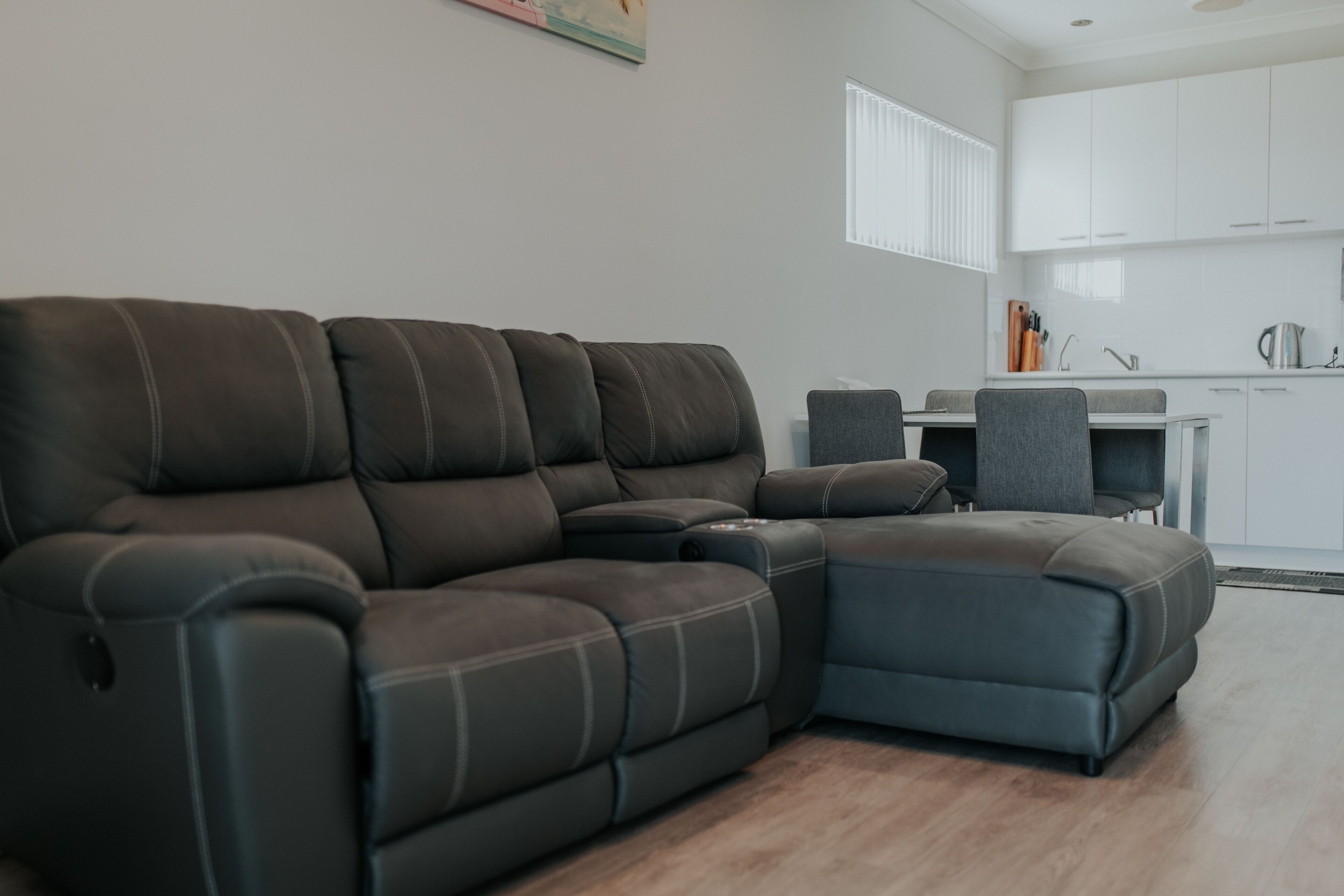 A modern living room with a sectional sofa and a dining area.