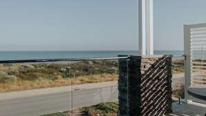 Un balcón con vista despejada a la carretera y al océano.